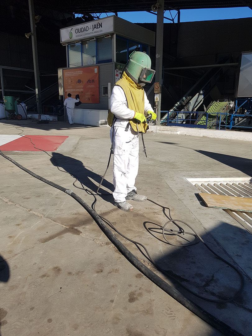Operario de Revinsur realizando chorreado con equipo de protección