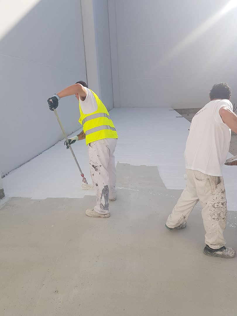 Equipo de pintores trabajando en un interior industrial